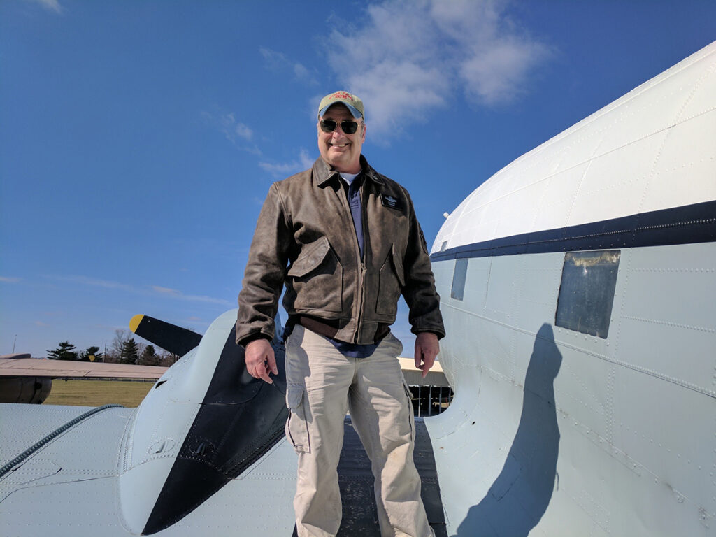 Pilot DJ Doran standing on the wing of a DC-3